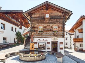 Das schön restaurierte und traditionelle Tiroler Haus vor dem Brunnen in Serfaus