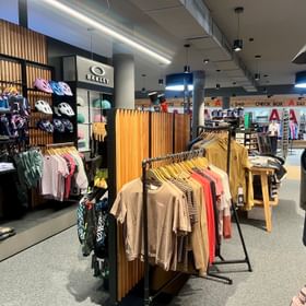 Eine große Auswahl an funktionaler Bekleidung und vielen anderen Accessoires zum Radfahren dekoriert an einer Wand im Check In Bikecenter Serfaus