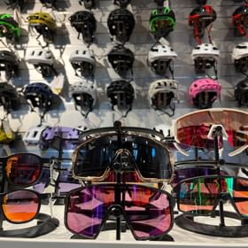 Sonnenbrillen zum Biken stehen vor einer Wand mit Helmen im Scott Testcenter Sportgeschäft Serfaus