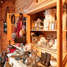 Holzschrank mit verschiedenen Wohnaccessoires und Souvenirs dekoriert im Geschäft Bsundrix
