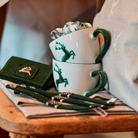 Kaffeetassen in Nahaufnahme mit Hirschdruck und Filztaschen in grün