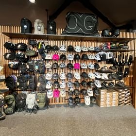 Alles zum Biken stehen vor einer Wand mit Helmen, Bikeschuhen, Rucksäcken und Hipbags im Check In Bikecenter Sportgeschäft 