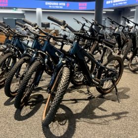 Im Geschäft stehen Mountainbike E-Fully Modelle der Marke Scott für Kinder in verschiedenen Größen zum Verleih