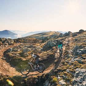 Zwei Biker fahren einen Trail in der Berglandschaft in Serfaus downhill