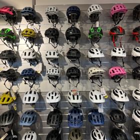 Eine Wand mit einer großen Auswahl an Helmen zum Biken und Fahrradfahren im Scott Testcenter Sportgeschäft Serfaus