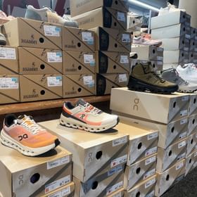 Eine Reihe von Schuhkartons und Schuhen der Marke On im Check In Bikecenter Geschäft in Serfaus