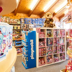 Innenansicht Spielwarenabteilung mit Regalen mit Barbie, Paw Patrol, Eisprinzessin und Playmobil Spielwaren für Kinder