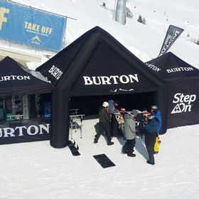 Vor dem Take Off stehen Gäste und Mitarbeite vor einem Pavillion mit Burton Snowboards und Step On Bindungen zum testen