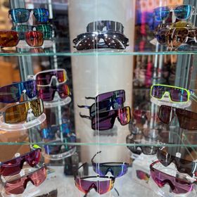 Vitrine mit Bikebrillen und Sonnenbrillen für jedes Wetter und Sportart der Marke Oakley mit Prizm Gläsern in verschiedenen Ausführungen und Farben
