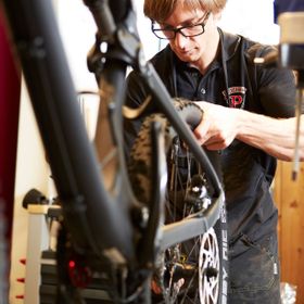 Ein Fahrradmechaniker vom Scott Testcenter Bikeshop wechselt fachmännisch die Mountainbikereifen