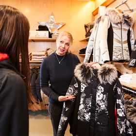 Eine Verkäuferin berät eine Kundin beim Kauf einer Moncler Jacke im Patscheider Sport Geschäft in der Modeabteilung in Serfaus