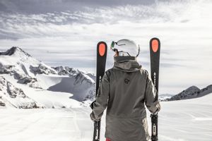 Eine Skifahrerin steht mit Kästle Ski in einer weißen Winterlandschaft in den Bergen