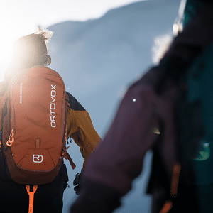 Zei Tourengeher laufen auf Tourenski mit einem Ortovox Rucksack einen Berg hinauf