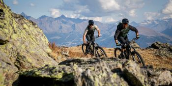 Zwei Männer fahren mit Fully Mountainbikes von Scott einen Trail durch eine raue Berglandschaft