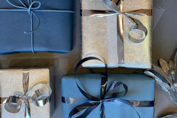 Nahaufnahme von verschieden großen Geschenken in blau und silber eingepackten Geschenkpapier mit Schleife