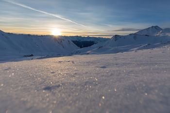 Sonnenaufgang mit winterlichen Bergpanorama im Masner Gebiet mit tief verschneiten Berghängen und Gipfeln im Skigebiet Serfaus-Fiss-Ladis