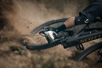 Ein Mann fährt auf einem Mountainbike einen staubigen Trail hinunter 