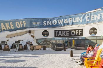 Der Außenbereich vor dem Take Off Snow & Funcenter an der Bergstation Komperdell mit gemütlichen Sitzsäcken zum chillen