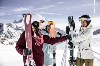 Eine Gruppe von Skifahrerinnen steht mit Kästle Ski in einer sonnigen, weißen Winterlandschaft 
