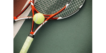Nahaufnahme von zwei übereinanderliegenden Tennisschlägern mit Ball