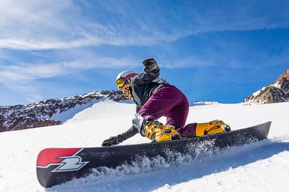Eine Frau carved auf eine Snowboard auf einer Pisten in einer weißen Berglandschaft