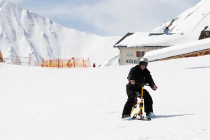 Ein Mann fährt auf einem Snowbike die Piste im Skigebiet Serfaus-Fiss-Ladis runter 