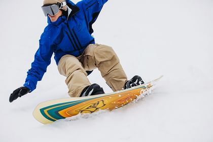 Eine Mann carved auf der Piste auf einem Burton Snowboard