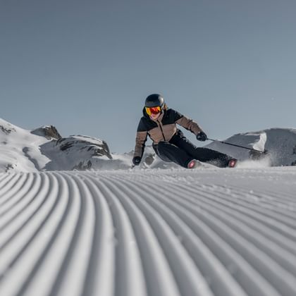 Eine Skifahrerin carved mit einem Ski der Marke Stöckli auf einer frisch präparierten Skipiste.