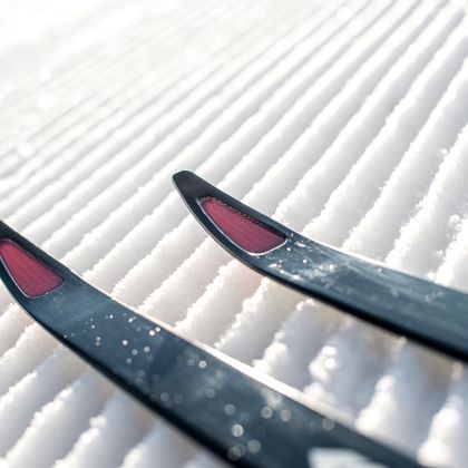 Die Spitzen eines Langlauf Skis der Marke Kästle auf einer präparierten Piste in Nahaufnahme