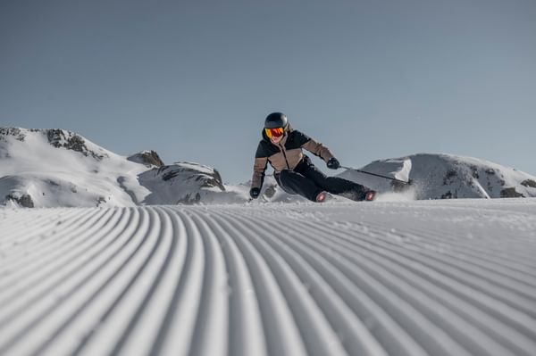 Eine Skifahrerin carved mit einem Ski der Marke Stöckli auf einer frisch präparierten Skipiste.