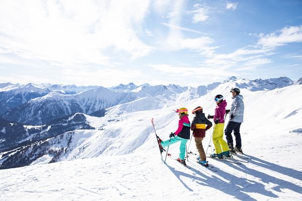 Eine Familie steht am Rand einer Piste im Skigebiet Serfaus und schaut in die weiße Berglandschaft
